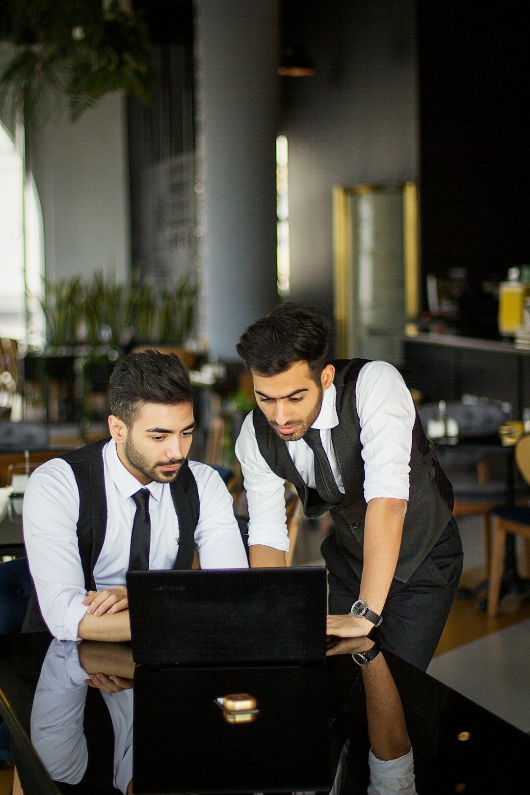 Diverse professionals collaborating around a laptop at a co-working table